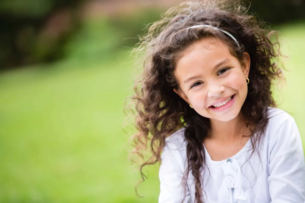 Smiling girl with curly hair outdoors